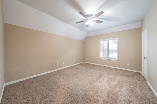 spare room with vaulted ceiling, ceiling fan, and carpet flooring