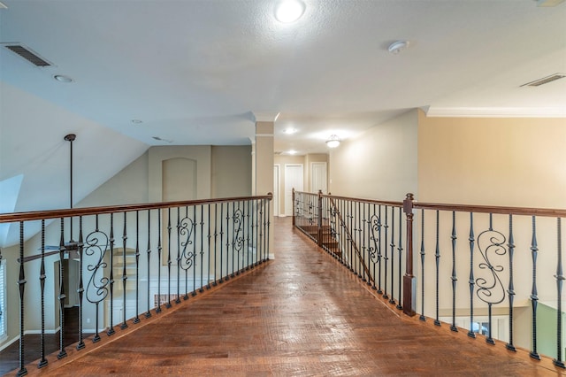 hall with vaulted ceiling, ornamental molding, hardwood / wood-style floors, and decorative columns