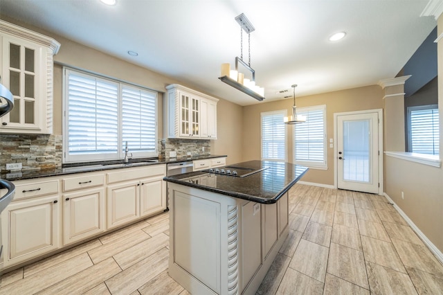 kitchen with pendant lighting, sink, dishwasher, a center island, and decorative backsplash