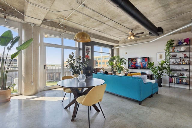 living room featuring plenty of natural light, concrete floors, and ceiling fan