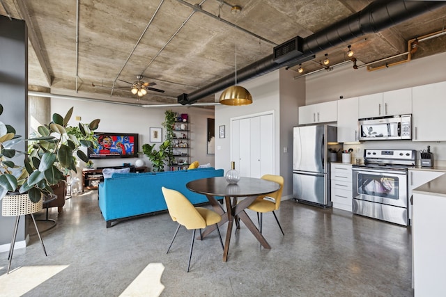 dining space featuring ceiling fan and a towering ceiling