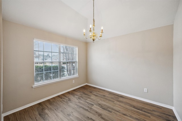 empty room with hardwood / wood-style flooring and a chandelier