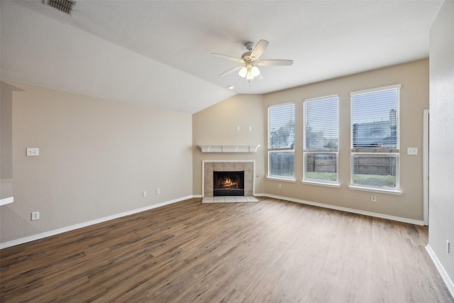 unfurnished living room featuring a tiled fireplace, hardwood / wood-style floors, vaulted ceiling, and ceiling fan