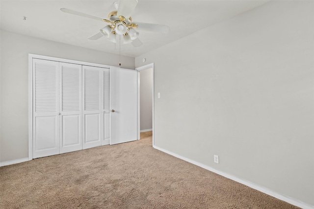 unfurnished bedroom featuring ceiling fan, a closet, and carpet