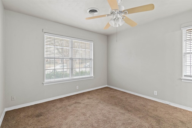 carpeted empty room featuring ceiling fan and a healthy amount of sunlight