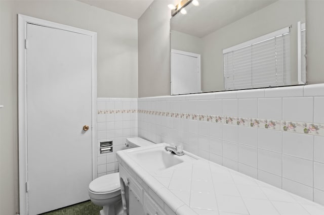 bathroom featuring vanity, toilet, and tile walls