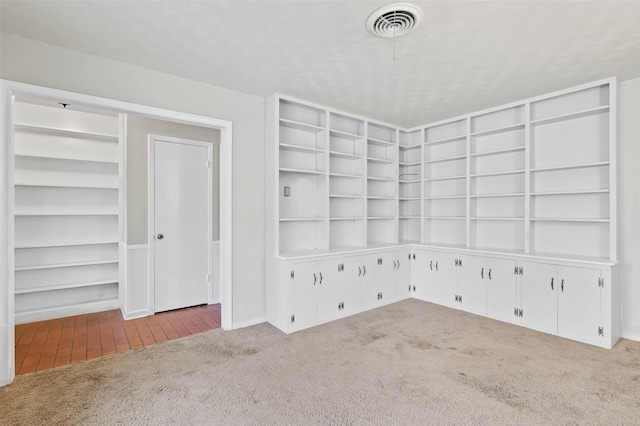 carpeted spare room with built in shelves