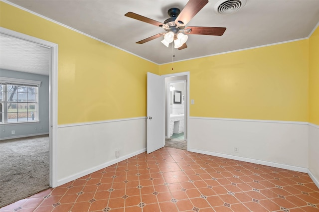 carpeted spare room with ornamental molding and ceiling fan