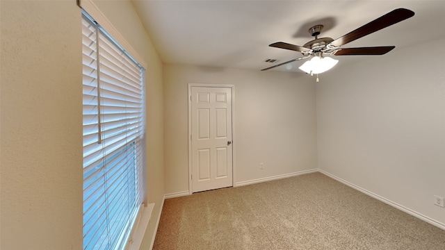 carpeted spare room with ceiling fan