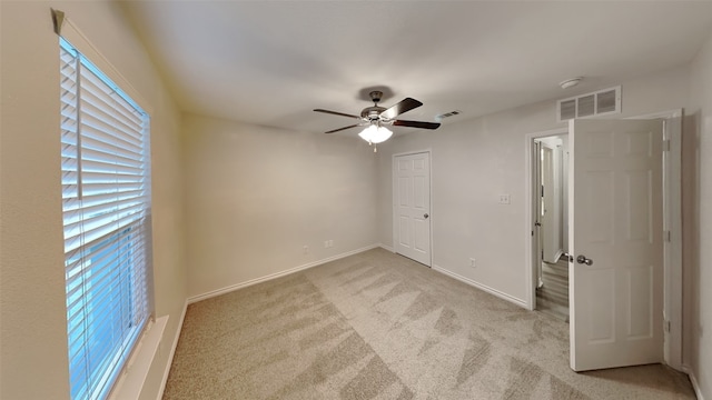 carpeted spare room with ceiling fan