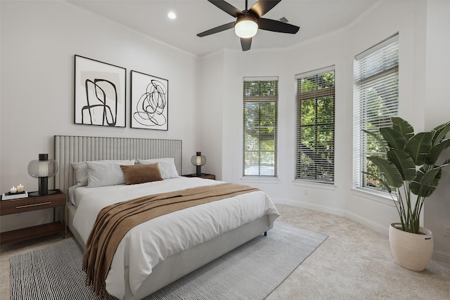 carpeted bedroom featuring ceiling fan and ornamental molding