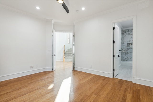 spare room featuring light hardwood / wood-style flooring, ornamental molding, and ceiling fan