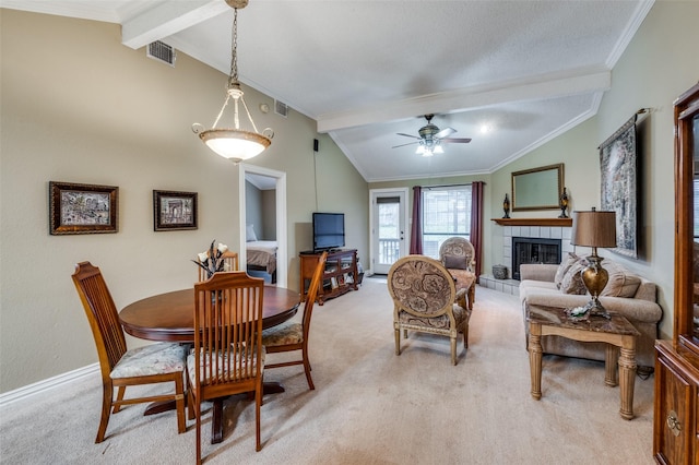 dining area with a tiled fireplace, light colored carpet, and lofted ceiling with beams