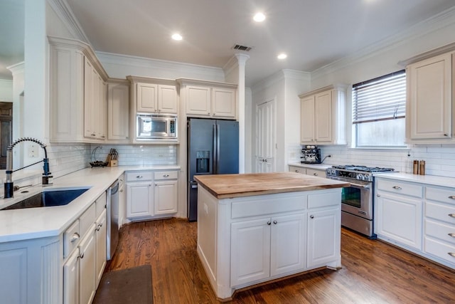 kitchen featuring white cabinetry, appliances with stainless steel finishes, butcher block countertops, and a kitchen island