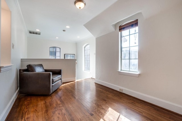 living area with hardwood / wood-style floors and crown molding