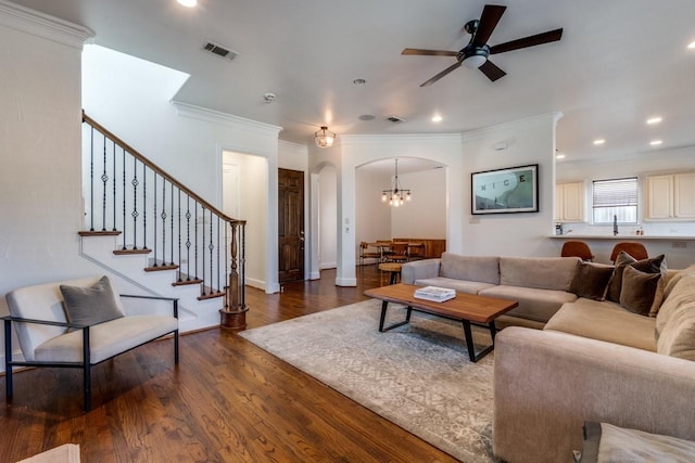 living room with crown molding, ceiling fan, and dark hardwood / wood-style floors