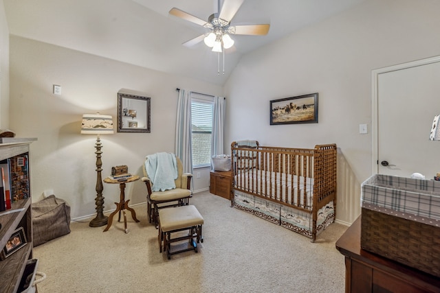 bedroom featuring lofted ceiling, a crib, ceiling fan, and carpet flooring