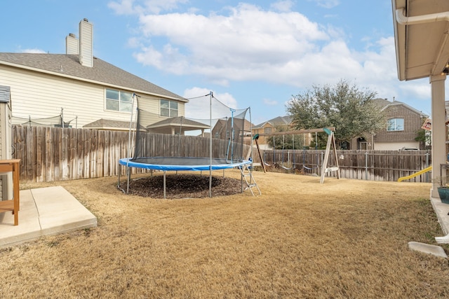 view of yard featuring a playground, a trampoline, and a patio area