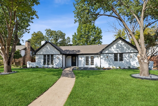 ranch-style home with french doors and a front lawn