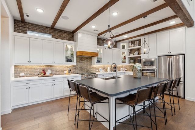 kitchen featuring sink, stainless steel appliances, white cabinets, and premium range hood