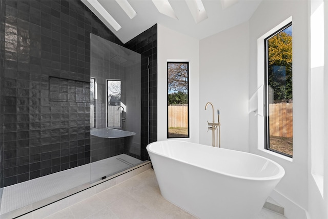 bathroom with tile patterned floors, a healthy amount of sunlight, separate shower and tub, and vaulted ceiling