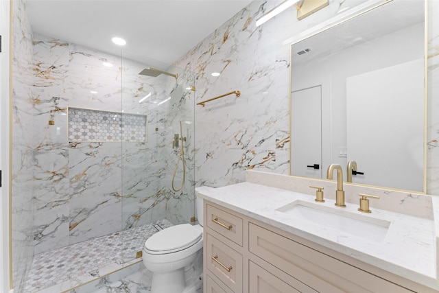 bathroom with vanity, toilet, and a tile shower