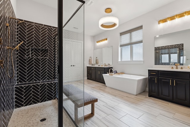 full bathroom featuring a freestanding bath, a sink, two vanities, and a shower stall