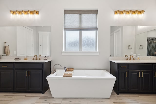 bathroom with a sink, a soaking tub, and two vanities