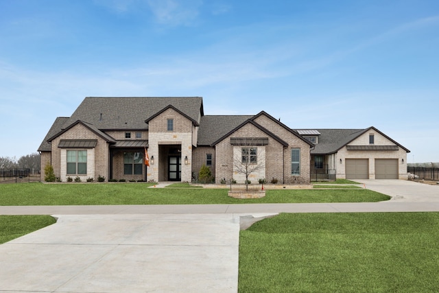 view of front of house with a standing seam roof, metal roof, a garage, driveway, and a front lawn