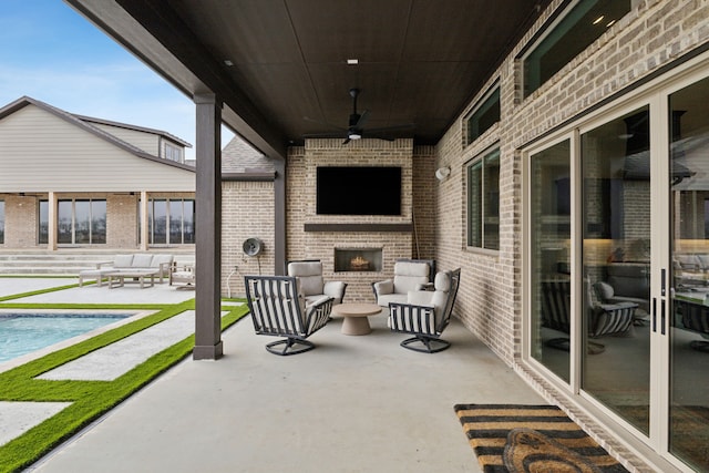 view of patio / terrace featuring ceiling fan and an outdoor living space with a fireplace