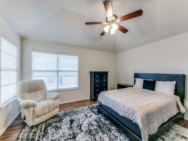 bedroom featuring lofted ceiling, dark hardwood / wood-style floors, a textured ceiling, and ceiling fan