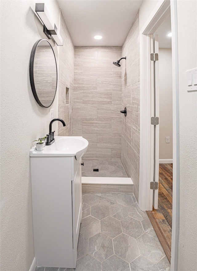 bathroom with vanity and a tile shower