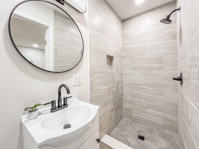 bathroom featuring vanity and tiled shower