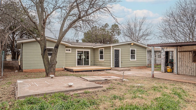 rear view of property featuring a wooden deck and a patio area