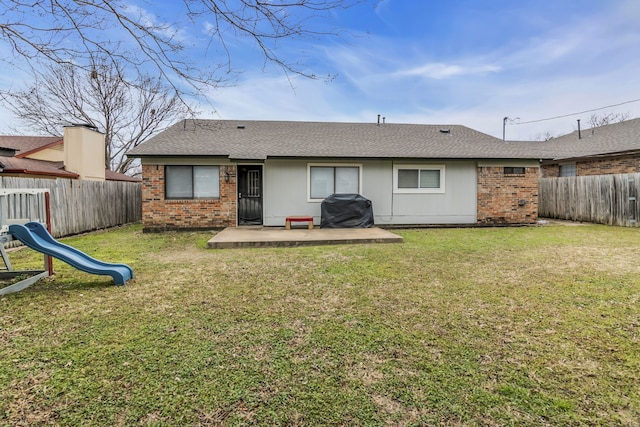 rear view of property with a playground, a patio, and a yard