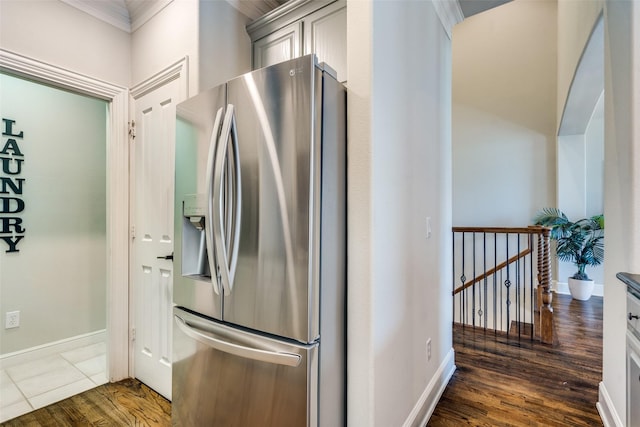 kitchen with stainless steel refrigerator with ice dispenser, crown molding, dark wood-type flooring, and gray cabinetry