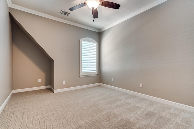 empty room with crown molding, light colored carpet, and ceiling fan