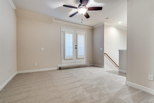 spare room featuring french doors, light colored carpet, ornamental molding, and ceiling fan