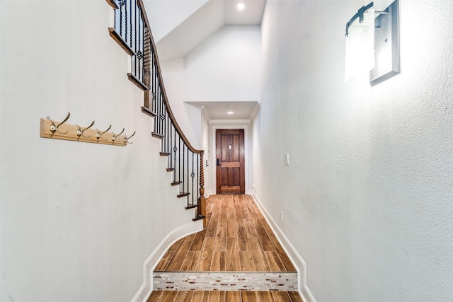 hallway with light hardwood / wood-style floors and a high ceiling