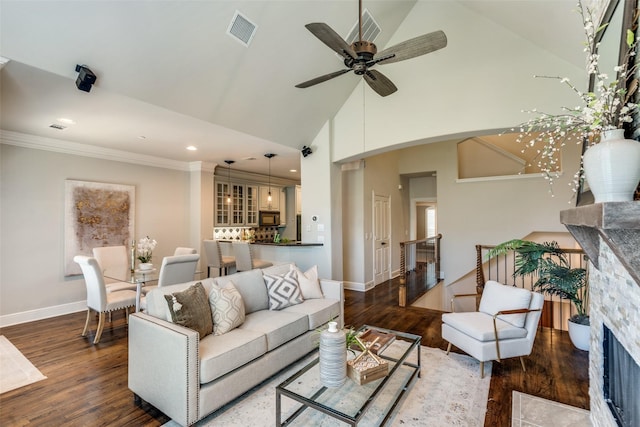 living room featuring high vaulted ceiling, a fireplace, ornamental molding, and dark hardwood / wood-style floors