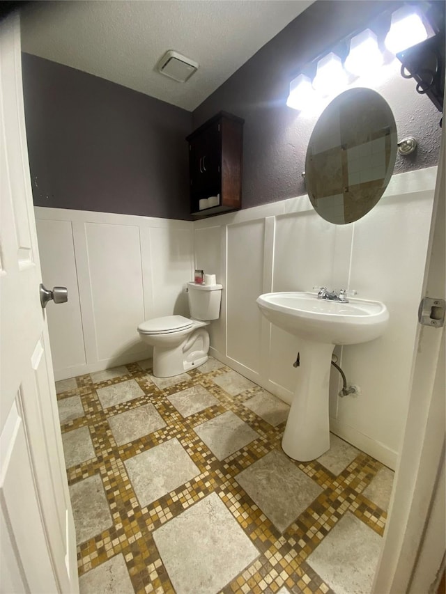 bathroom with a textured ceiling and toilet