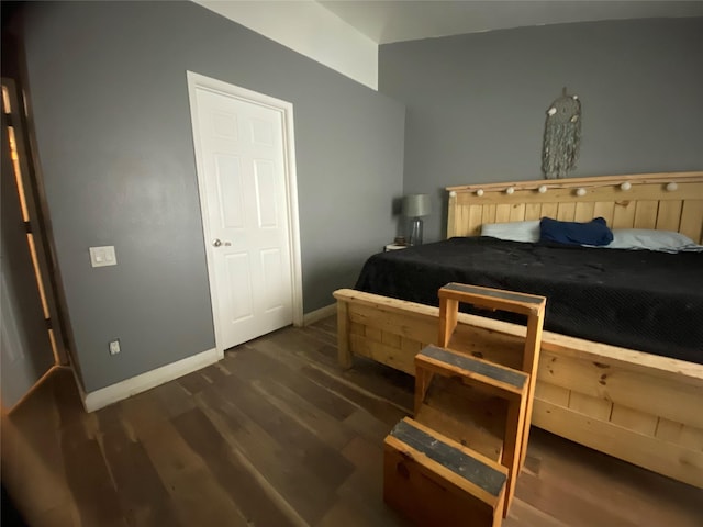 bedroom with dark hardwood / wood-style flooring