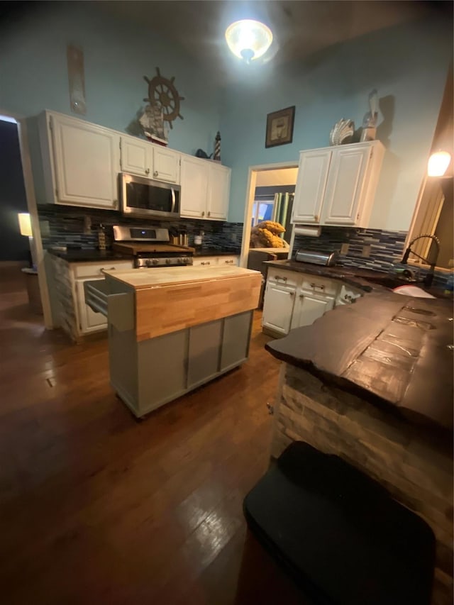 kitchen with dark hardwood / wood-style flooring, stainless steel appliances, and white cabinets