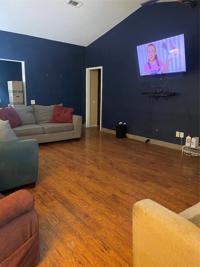 living room featuring lofted ceiling and hardwood / wood-style flooring