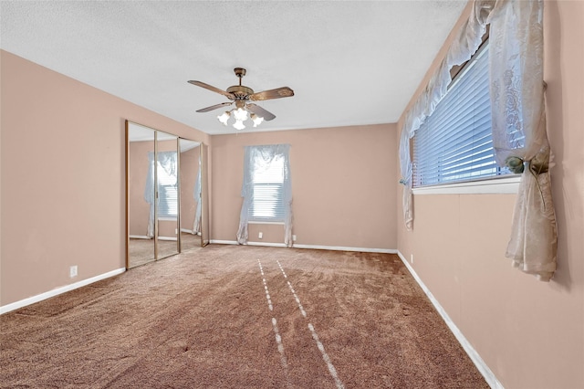 carpeted empty room with a textured ceiling and ceiling fan