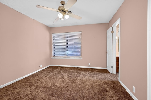 empty room with ceiling fan and dark carpet