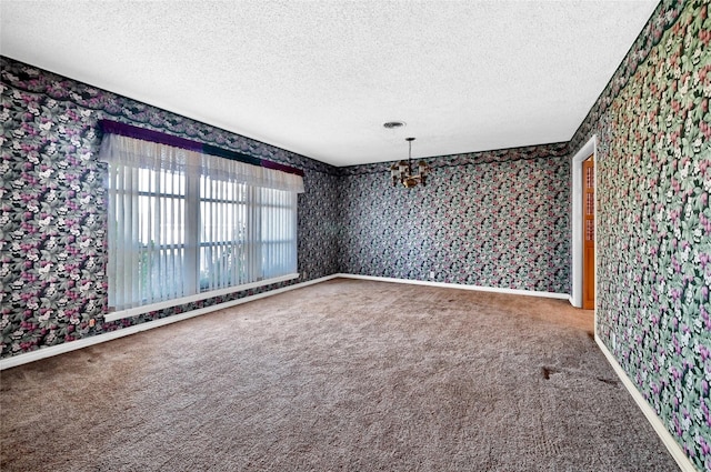 carpeted empty room featuring a textured ceiling