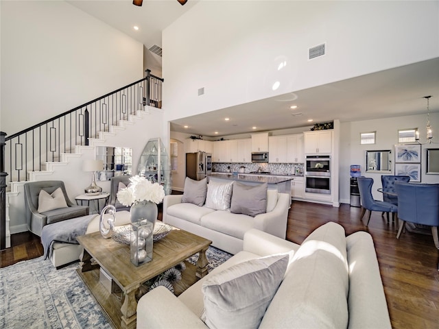 living room featuring dark hardwood / wood-style floors and ceiling fan with notable chandelier