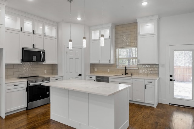 kitchen featuring sink, a center island, stainless steel appliances, light stone countertops, and white cabinets