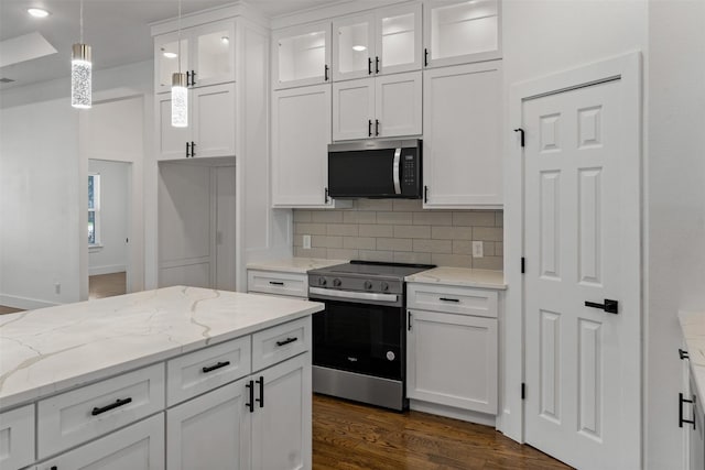 kitchen with appliances with stainless steel finishes, pendant lighting, and white cabinets